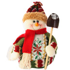 Decorative snowman figurine with a red scarf, green jacket, and a small shovel 