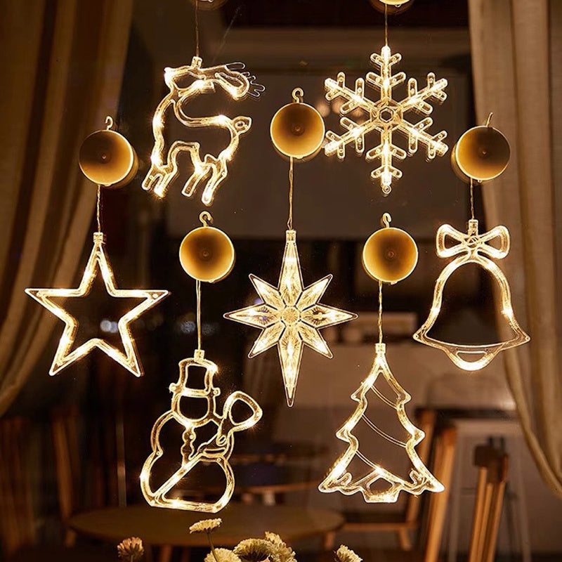 Decorative hanging lights shaped like stars, snowflakes, deer, bells, and trees in a warm glow.