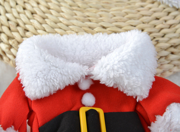Close-up of a red Santa Claus costume with white fur trim on a woven surface.