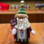 Knitted Santa Claus figure holding a 'Let It Snow' sign 