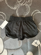 Black Lululemon shorts with a tag on a patterned surface