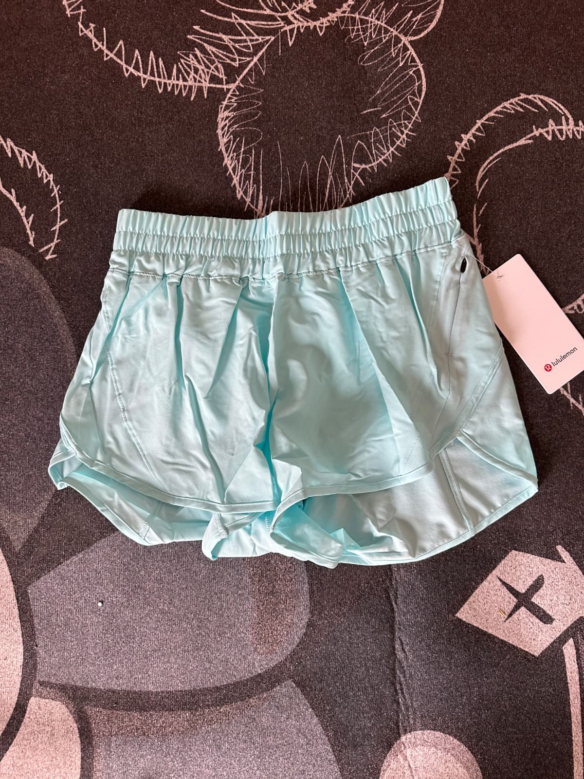 Light blue Lululemon shorts on a dark patterned surface