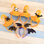 Set of Halloween-themed headbands with pumpkins, bats, and spiders on a wooden surface.