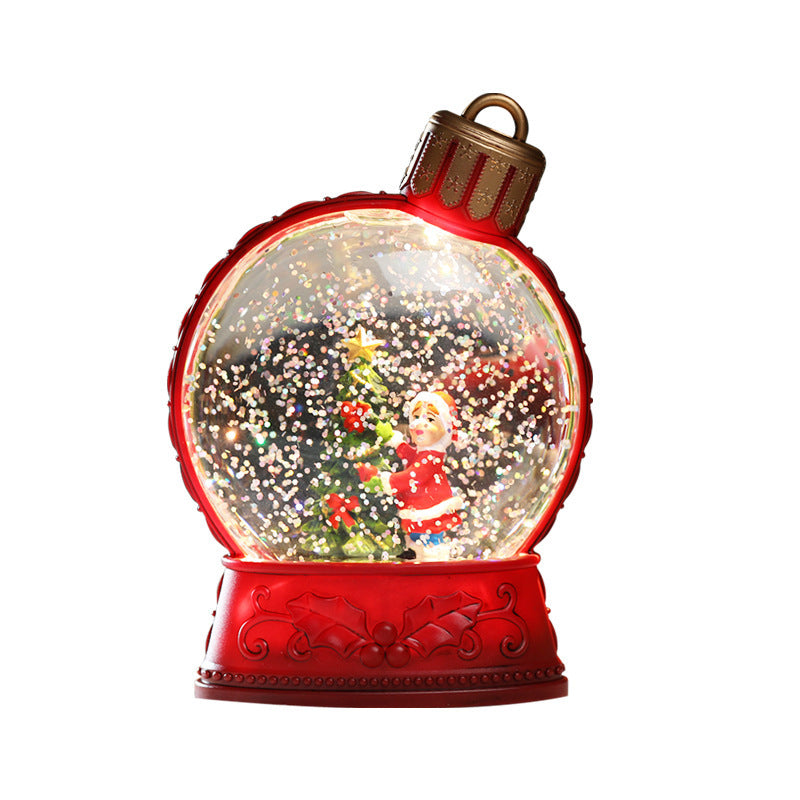 Red snow globe with a Christmas scene inside on a white background